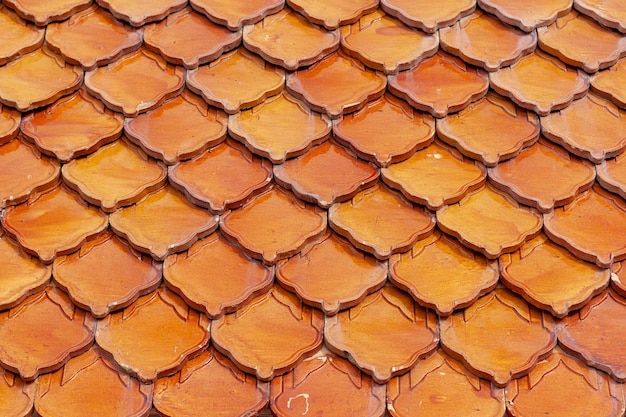 Orange clay tiles overlapping each other on the roof Geometric pattern from old tile Selective focus Shallow DOF Horizontal