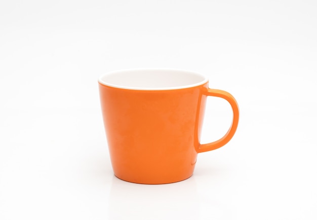 Orange color empty tea cup on isolated white background with reflection