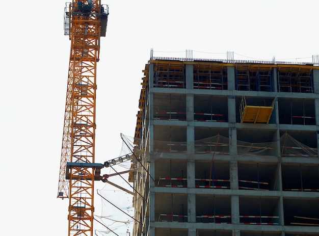 Orange construction crane near building site