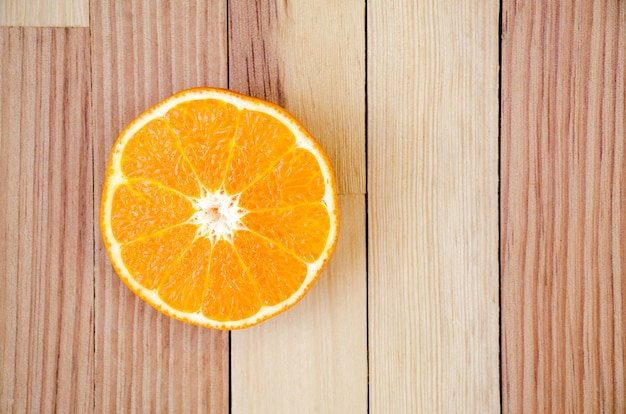 The orange cut in half on a wooden table