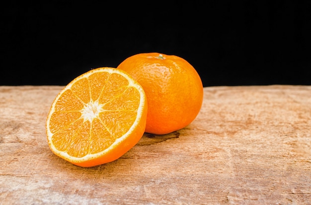 The orange cut in half on a wooden table