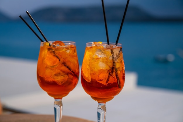 Orange drink or cocktail standing at the little table at the restaurant or cafe with sea background