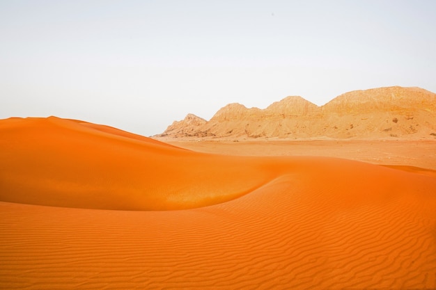 Orange Dubai desert background with mountain and sand