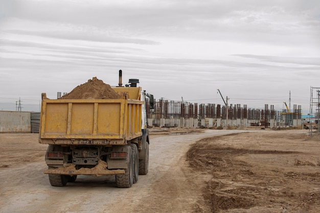 An orange dumper truck in an construction area