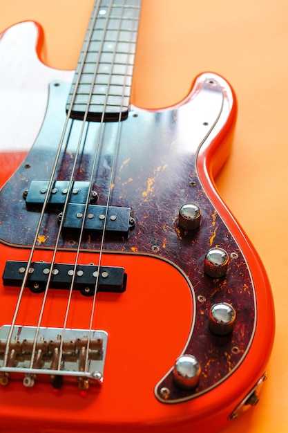 orange electric bass guitar on wood background with copy space