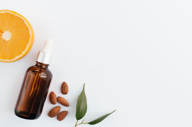 Orange essential oil in glass bottle with green leaf