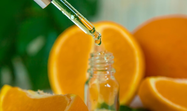 Orange essential oil in a small bottle Selective focus