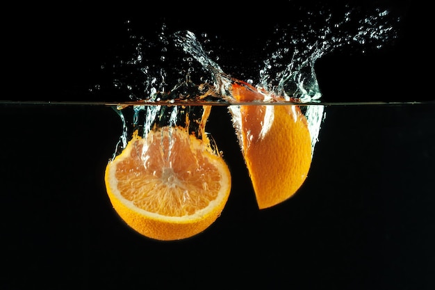 Orange falls into the water and making splashes