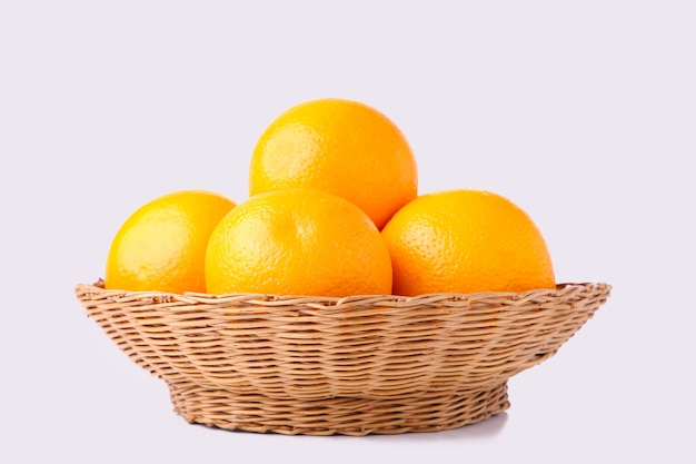 Orange fruit in basket on a white background