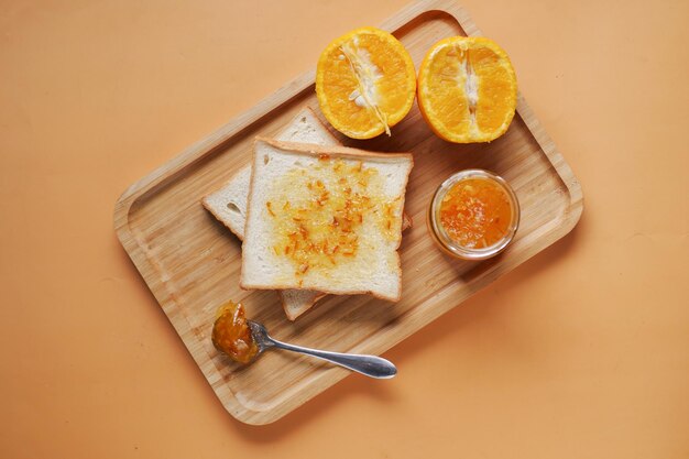 Orange fruit spread on a bread on table