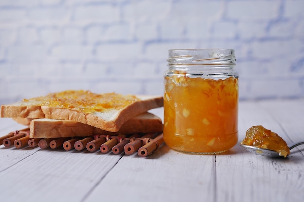 Orange fruit spread on a bread on table