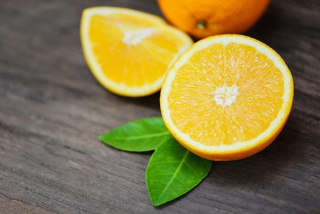 Orange fruit on wooden background Fresh orange slice half and orange leaf healthy fruits harvest concept