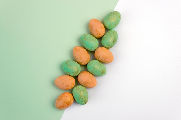 Orange and green Easter eggs on a green and white background Copy space Geometry