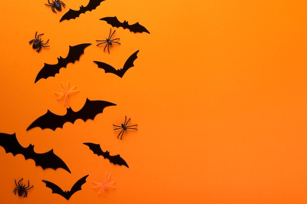 Orange Halloween background Flock of black bats for Halloween Black paper bat silhouettes on orange background Halloween concept Copy space top view overhead