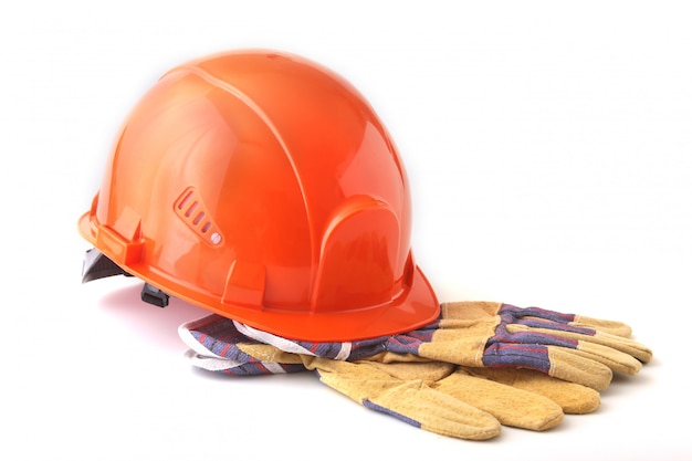 Orange hard hat, safety gloves on white background. Safety helmet.