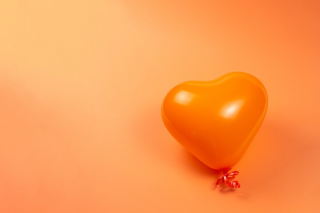 Orange heart ballon on orange.