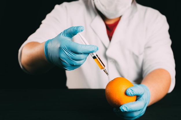 Orange injection lab technician in Bathrobe and gloves colitis nitrates and GMO in Orange on black background