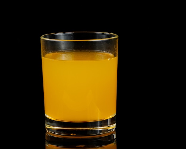 Orange juice in a glass isolated on black