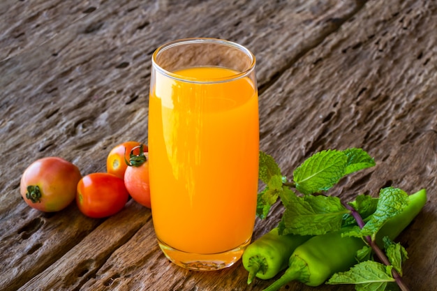 Orange juice in glass with mint on wooden background