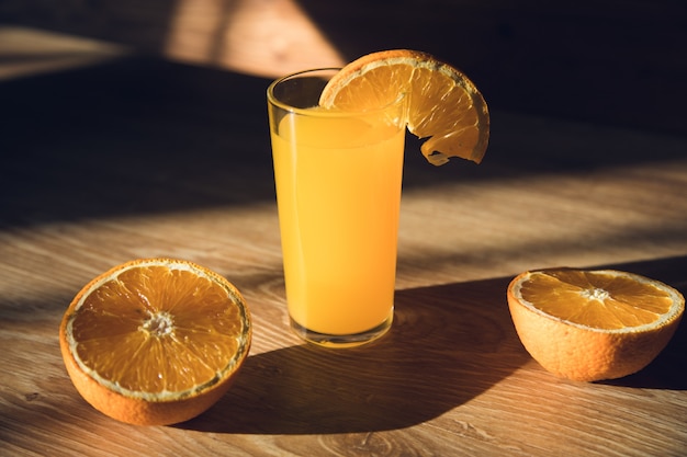 Orange juice sliced oranges on a wooden table