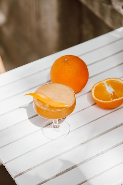 Orange Juice on a white table with half cut orange