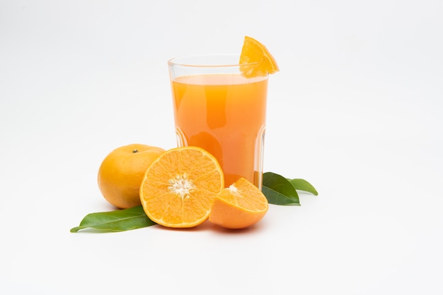  Orange juice with pulp and sliced fruits on white table.