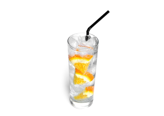 Orange lemonade with ice in a clear glass isolated.