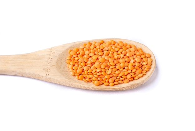 Orange lentil in a spoon isolated over white background