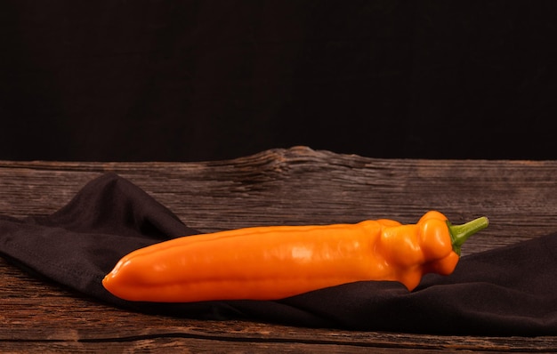 Orange long pepper on an old rustic wooden table space for text