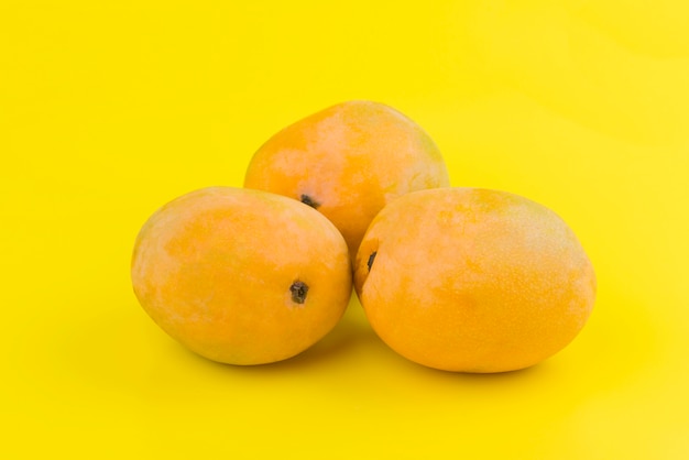 Orange mango on yellow background