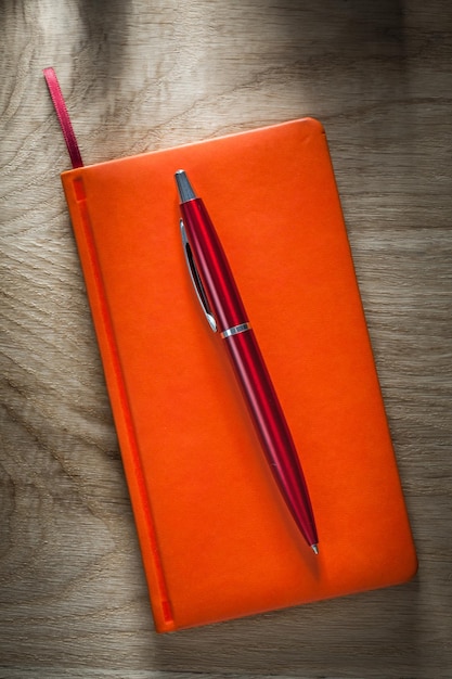 Orange notebook biro pen top view