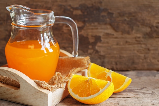 Orange and orange juice on wooden background