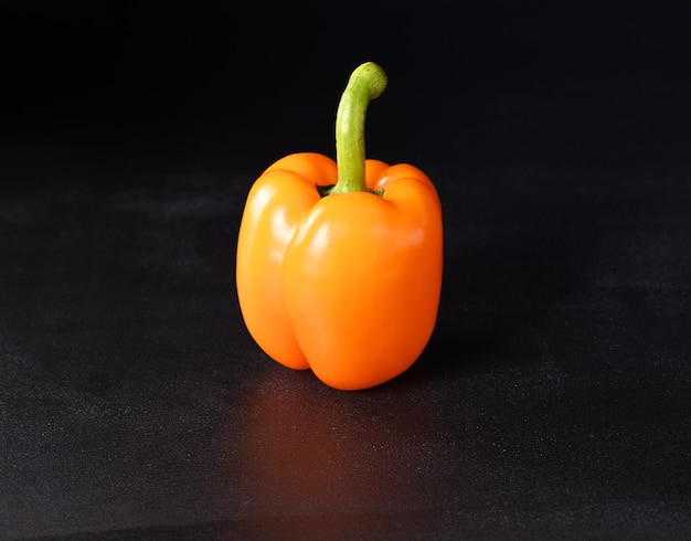 Orange paprika on a dark background.