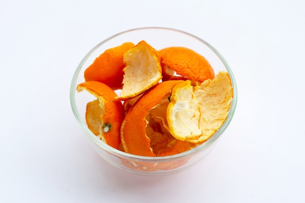 Orange peels in glass bowl on white surface