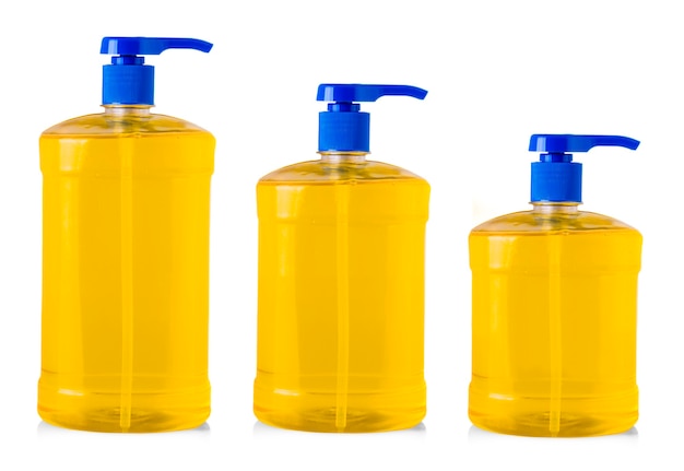 Orange plastic bottles with liquid laundry detergent, cleaning agent, bleach or fabric softener isolated on white background