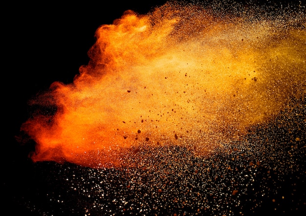 Orange powder explosion isolated on black  background