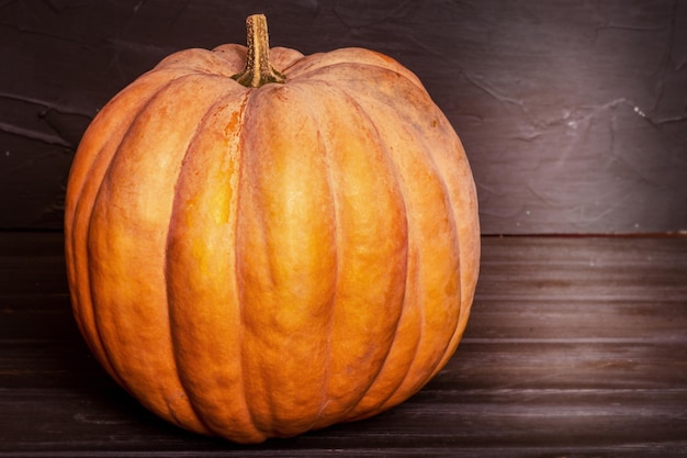 Orange pumpkin on a black wooden background Harvest Halloween