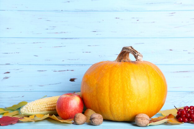 Photo orange pumpkin with leaves on a blue background