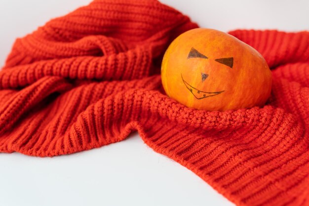 An orange pumpkin with a painted face The concept of the holiday on October 31 Halloween Place for an inscription