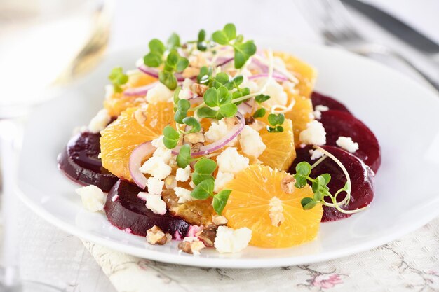 Orange salad with baked beetroot goat cheese microgreens and nuts