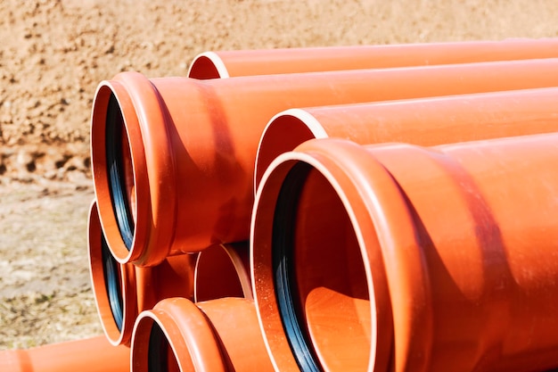 Orange sewer pipes at the construction site Preparation for the installation of an underground sewer system Wastewater disposal