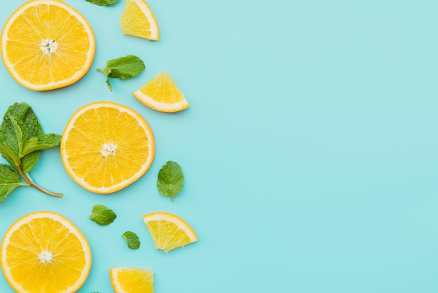 Orange slices and mint leaves on background