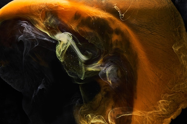 Orange smoke on black ink background, colorful fog, abstract swirling ocean sea, acrylic paint pigment underwater