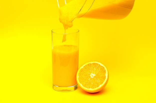 Orange smoothie on yellow background, homemade smoothie,glass smoothie