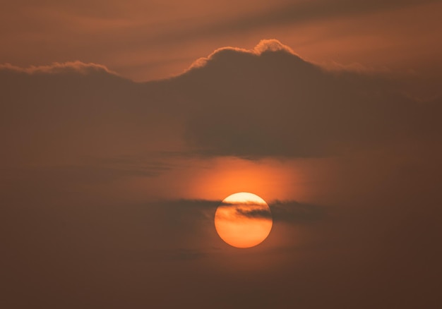 Orange sun in the clouds. Romantic sunset. Beauty of nature.