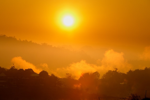 Orange Sun up to Sunrise over mountain and reflect on river with morning fog smoke.