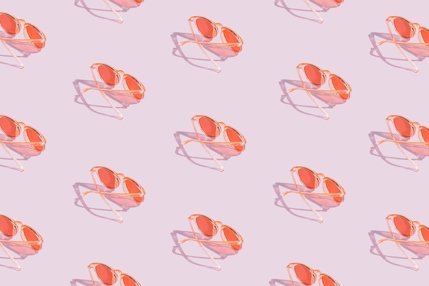 Orange sunglasses pattern on violet pastel background. Minimal summer concept. Isometric layout