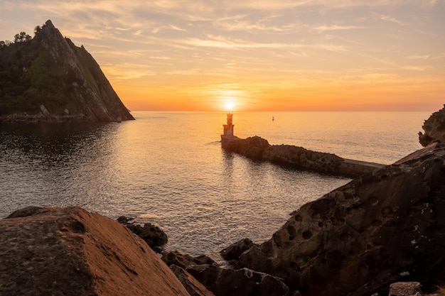 Orange sunset at the Lighthouse of the bay of Pasaia in the town of San Juan Gipuzkoa Basque Country