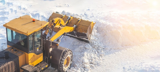 Orange tractor removes snow from the road and clears the sidewalk.Snow removal after snowfalls