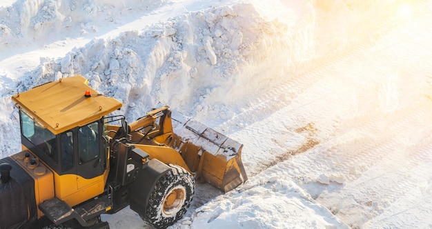 Orange tractor removes snow from the road and clears the sidewalk.Snow removal after snowfalls